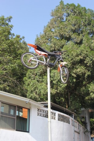 An orange dirt motor bike on a pole