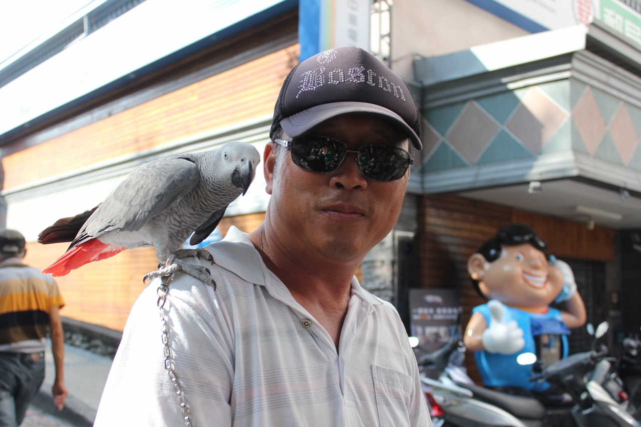 A man with a parrot on his shoulder